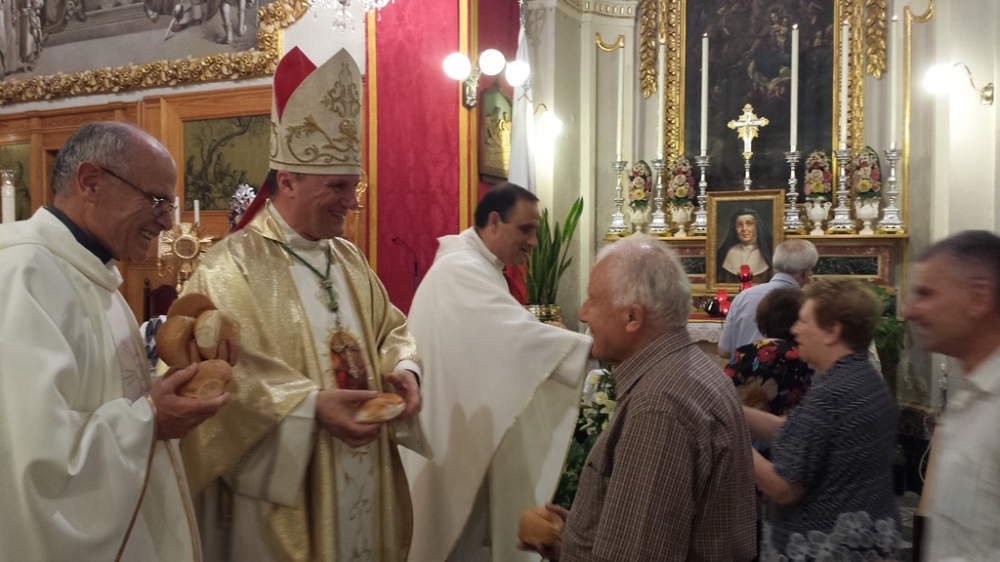 L-Isqof joffri l=ħobż ta' Sant Antin fil-festa fit-13 ta' Ġunju