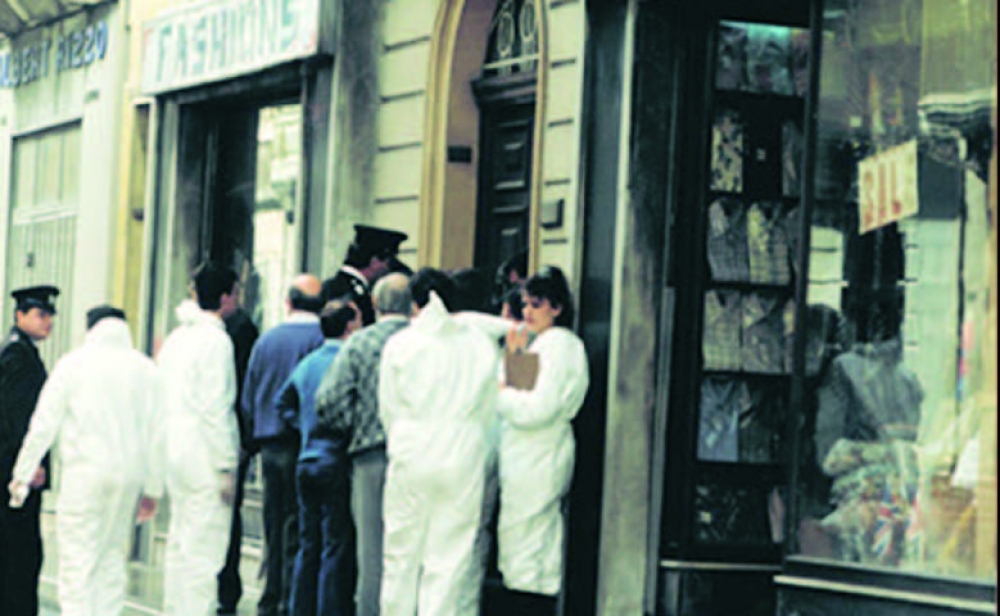 Pulizija tal-Forensika u tad-Distrett flimkien ma’ qraba tal-koppja Briffa barra l-ħanut tal-vittmi