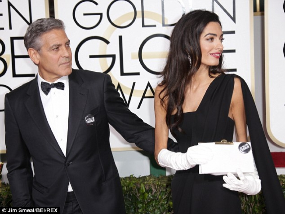 L-attur George Clooney ma' martu bil-badges 'Je suis Charlie' qabel iċ-ċerimonja tal-Gloden Globes