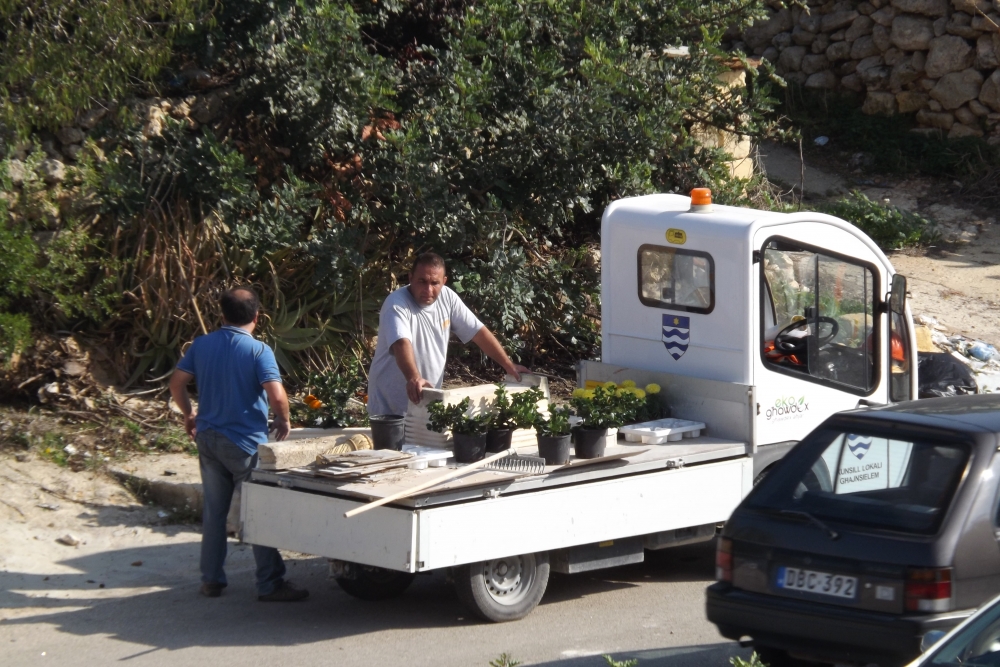 is-sindku t'Għajnsielem (bi flokk blu) jidher jgħin fit-tindif tal-lokal
