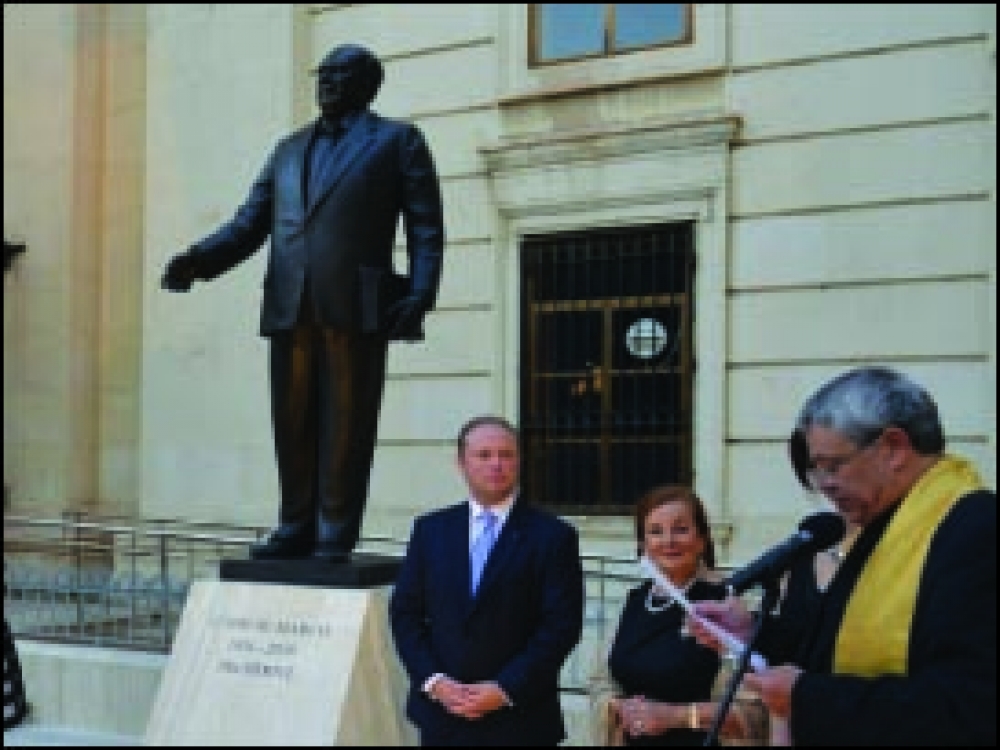 Guido de Marco b’id waħda qisu biex jieħu b’idejn lin-nies u f’id l-oħra qed iżomm kopja tal-bijografija tiegħu 
