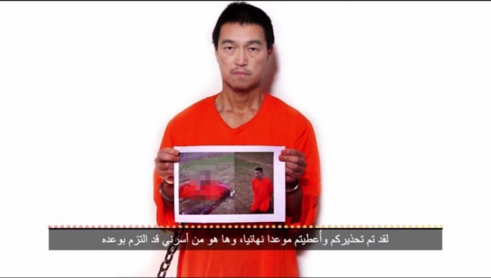 Kenji Goto jżomm ir-ritratt ta' Haruna Yukawa b'rasu maqtugħa