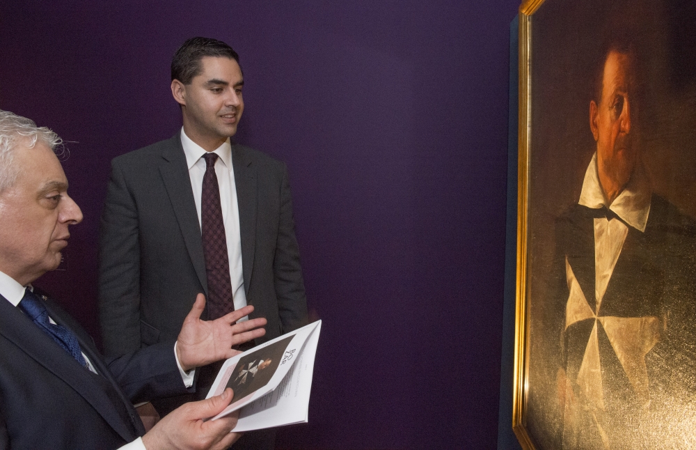 L-ambaxxatur Ray Azzopardi jfiehem lis-segretarju parlamentari Ian Borg xi tfisser eżatt il-pittura tal-caravaggio li hemm għall-wiri: Ritratt: Ray Attard